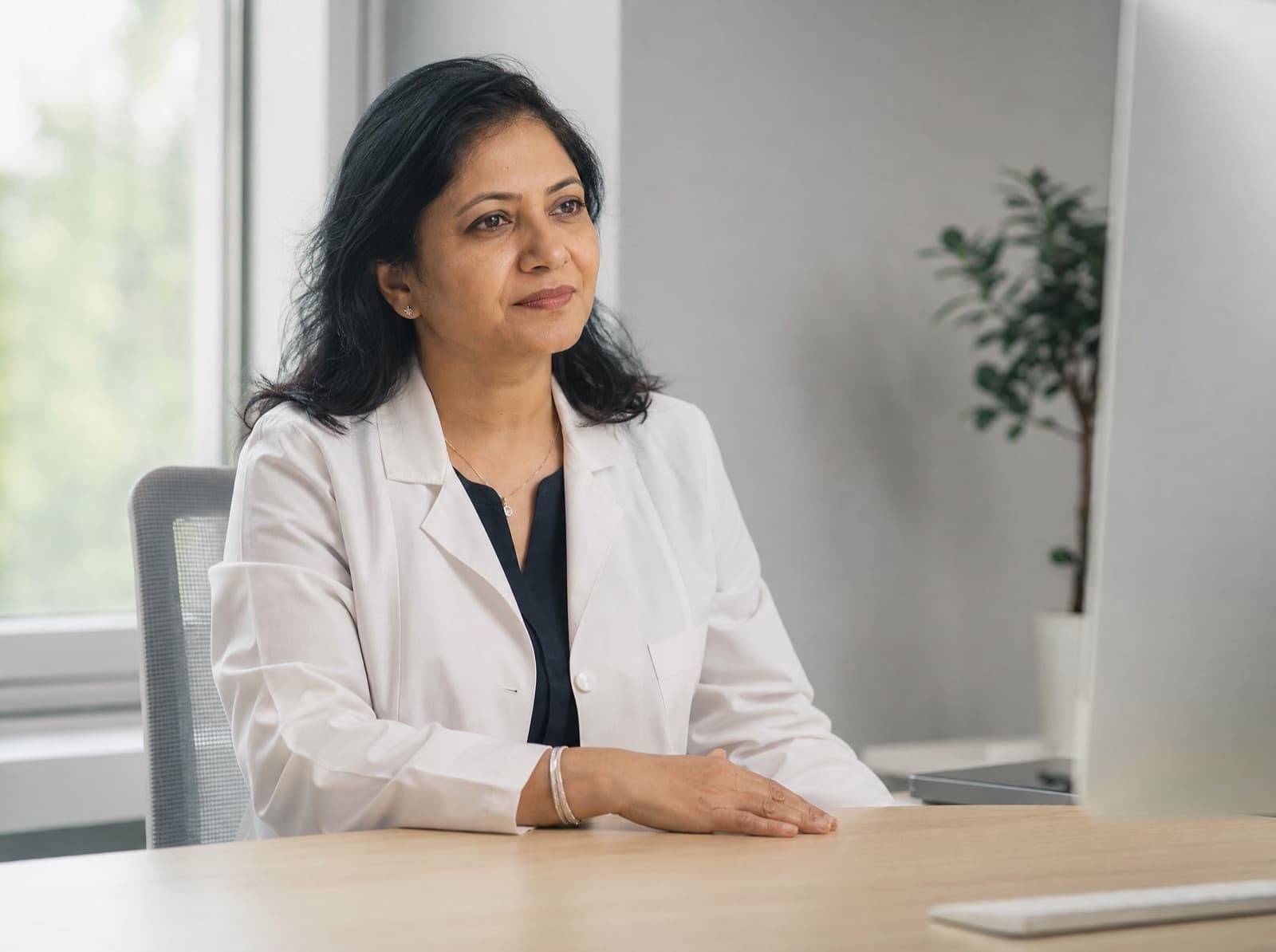 A Nivar doctor at her desk reviewing a patient's live readings on a monitor