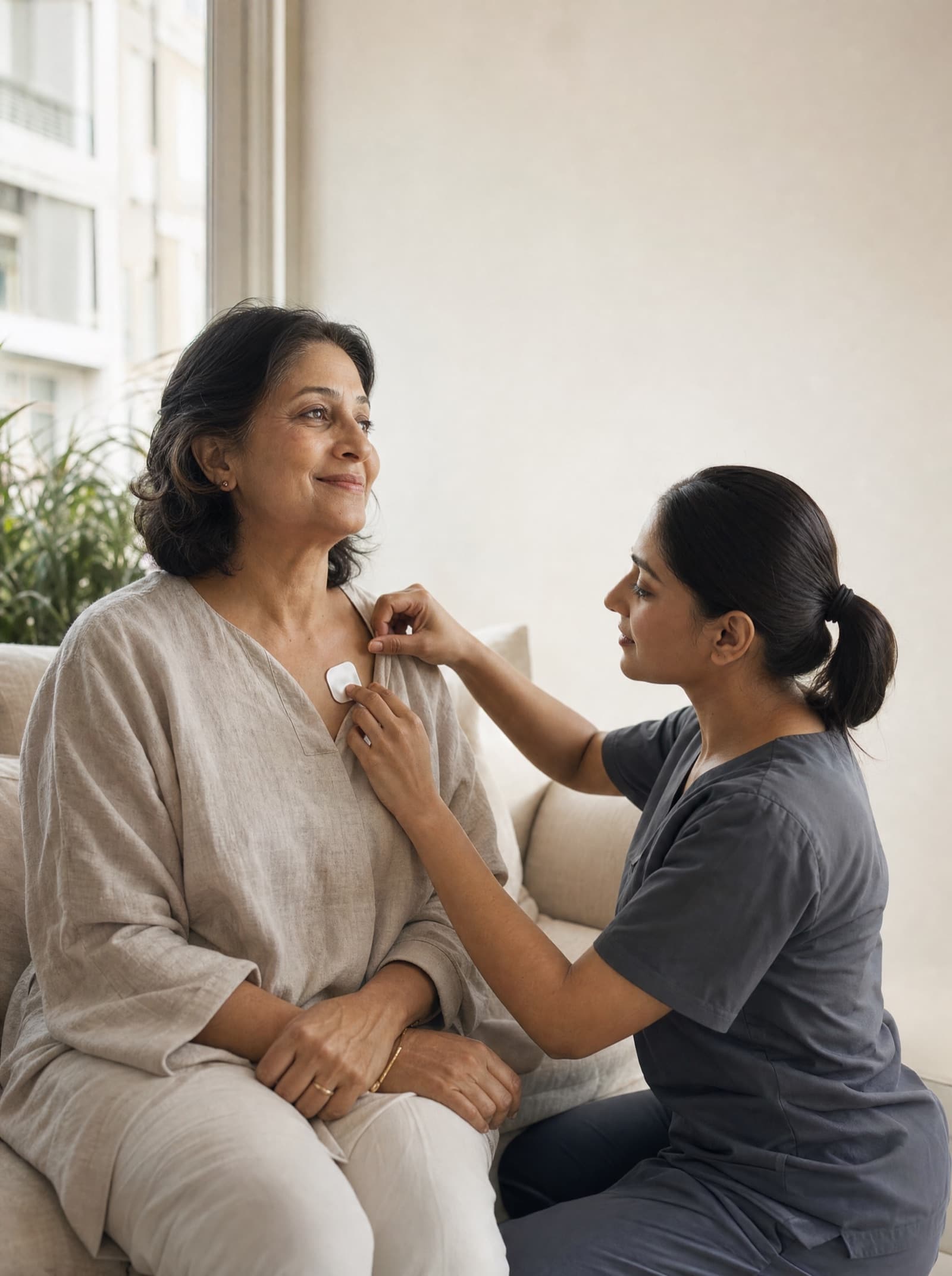A Nivar nurse placing a smart ECG patch on a woman seated at home